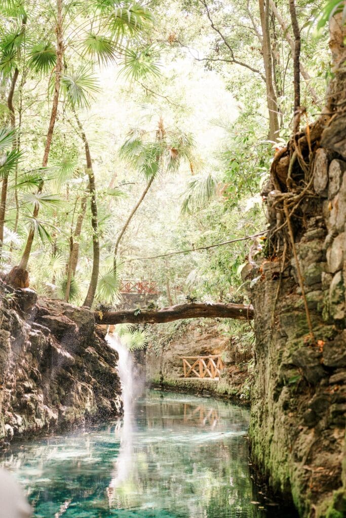 Lush jungle waterfall and turquoise river at Hotel Xcaret Mexico in the Riviera Maya near Cancún, a beautiful destination wedding resort in Playa del Carmen.